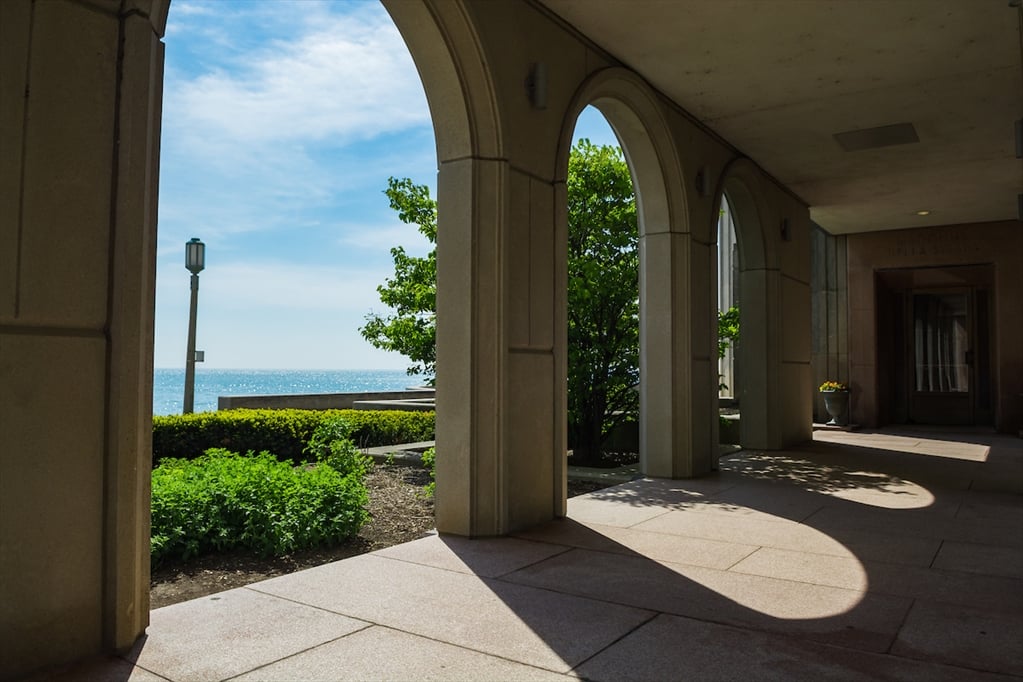 Lake Michigan on a sunny day, as seen through the arches of covered walkway on Lakeshore Campus.